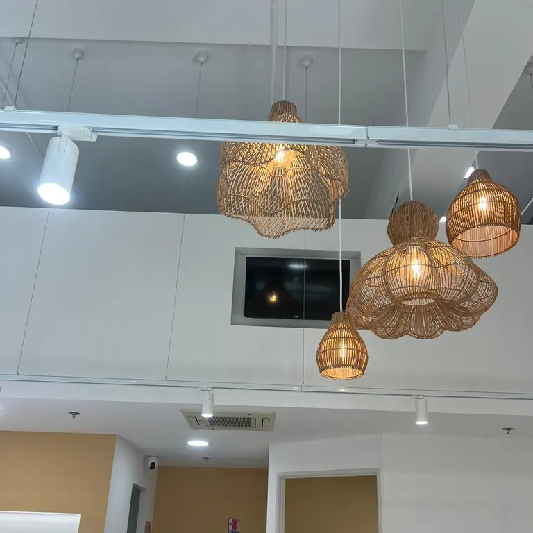 Suspensions en rotin et spots orientables en cours de réglage