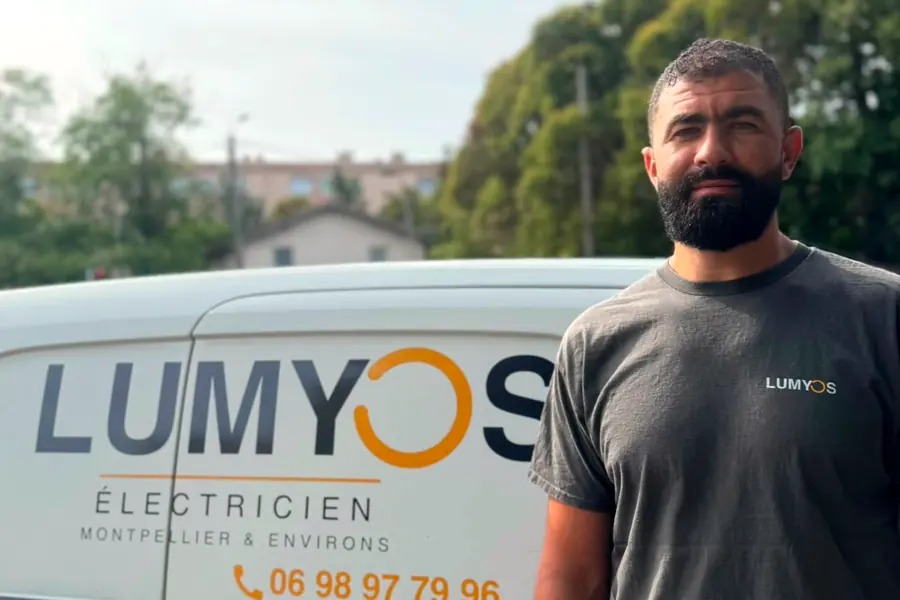 Zouhir, électricien Lumyos, devant son véhicule professionnel